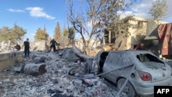 People check the destruction at the site of an Israeli airstrike that targeted the eastern village of Bazzaliyeh in the Hermel district of Lebanon's Bekaa valley, near the border with Syria, on November 1, 2024, amid the ongoing war between Israel and Hez