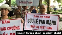 Bà Nguyễn Thị Việt (phải) giơ biểu ngữ kêu oan cho con trai Lê Văn Mạnh, người bị kết án tử hình vì tội "giết người" và "hiếp dâm" vào năm 2015, ở Hà Nội hôm 21/9.