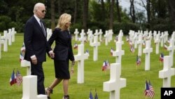 Prezidan Joe Biden ak premye dam Jill Biden mache nan simitye Ameriken Normandy a apre yon seremoni pou komemore 80e anivese D-Day, 6 Jyen 2024.