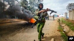 Foto Achiv: Yon polisye Kenyan pare pou lanse gaz lakrimojen kont manifestan nan Kibera, yon katye nan kapital la, Nairobi, 19 Jiye, 2023.