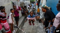 A girl plays a jump rope game at a school housing residents displaced by gang violence in Port-au-Prince, Haiti, May 15, 2024.