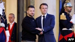 Ukraine's President Volodymyr Zelensky (L) is welcomed by France's President Emmanuel Macron upon his arrival at the Elysee presidential palace in Paris, May 14, 2023.