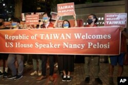 Moun Taiwan kenbe yon banye devan otel kote Lide La Chanm de Reprezantan Nancy Pelosi desann nan Taipei, Taiwan pou swete li byenvini, 2 Out 2022.