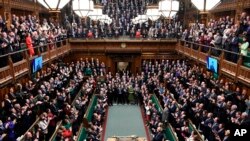 Ukrainian President Volodymyr Zelenskyy is displayed on the screen as he addresses British lawmakers in the House of Commons in London, Thursday March 8, 2022.