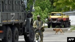 FILE - A Russian serviceman patrols a street in Kherson, amid Russia's ongoing invasion of Ukraine. May 20, 2022.