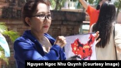 Người biểu tình giơ cao hình ảnh về bản đồ tuyên bố chủ quyền gần như toàn bộ biển Đông của Trung Quốc, hay còn được gọi là “đường lưỡi bò”.