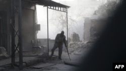 Un homme syrien blessé marche dans la rue couverte de poussière suite aux bombardements du gouvernement sur la ville rebelle de Hamouria, dans la région de la Ghouta orientale assiégée à la périphérie de la capitale Damas le 5 mars 2018.