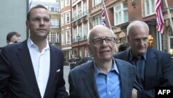 Ông Rupert Murdoch (giữa) và James Murdoch (trái) tại London, ngày 10/7/2011