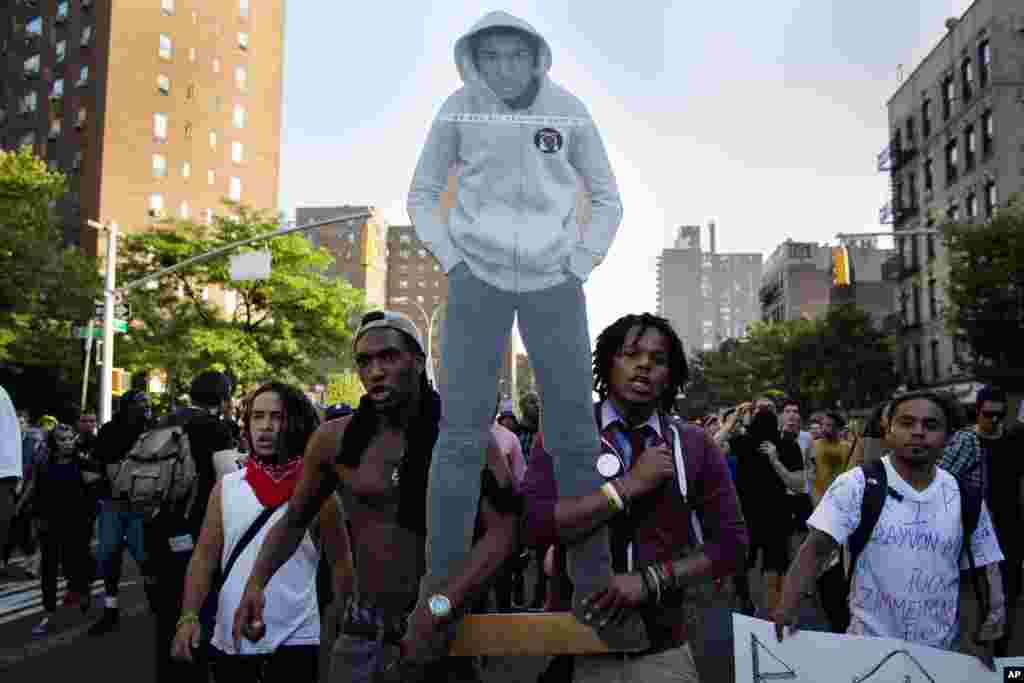 Người biểu tình cầm bìa in hình thiếu niên Trayvon Martin trong một cuộc tuần hành ở New York, 14 tháng 7, 2013.