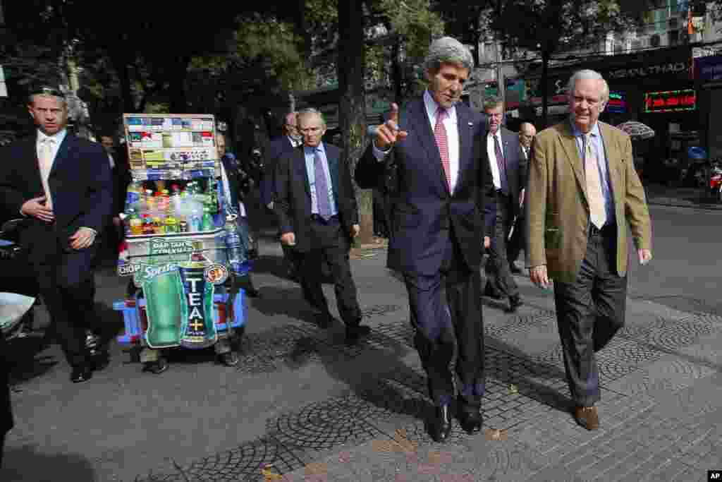 Ông Kerry cùng ông Tommy Vallely, bạn đồng ngũ và cựu chiến binh Chiến tranh Việt Nam, đi bộ trên đường phố Sài Gòn đến Nhà thờ Đức Bà để dự thánh lễ. Ông Kerry từng phục vụ tại Việt Nam 44 năm trước khi còn là một sĩ quan hải quân trẻ tuổi.