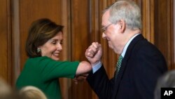 Chủ tịch Hạ viện Nancy Pelosi (thuộc Đảng Dân chủ), trái, và Lãnh đạo khối Đa số ở Thượng viện Mitch McConnell (thuộc Đảng Cộng hoà) tại một buổi gặp ở Điện Capitol ở thủ đô Washington. Hai đảng đối lập đang bất đồng quan điểm trong các gói cứu trợ kinh tế giữa dịch COVID-19.