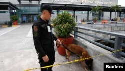 Cảnh sát và chó nghiệp vụ tại sân bay quốc tế Ninoy Aquino ở thành phố Pasay, Manila, ngày 1/9/2014.