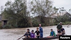 Cư dân địa phương chèo thuyền đến địa điểm phát phẩm vật cứu trợ cho người dân bị lụt tại thôn Quảng An, Thừa Thiên-Huế. Ảnh chụp ngày 20/10/2020.