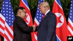 Tổng thống Mỹ Donald Trump bắt tay với lãnh tụ Triều Tiên Kim Jong Un tại khu resort Capella trên đảo Sentosa, Singapore, ngày 12 tháng 6, 2018.