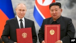 Tổng thống Nga Vladimir Putin (trái) và nhà lãnh đạo Triều Tiên Kim Jong Un cùng chụp ảnh trong một lễ ký kết đối tác mới ở Bình Nhưỡng hôm 19/6/2024. 