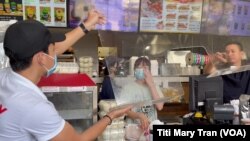 Tấm kính phòng ngừa COVID-19 được tháo xuống tại một tiệm food-to-go trong vùng Little Saigon sau khi California có lệnh mở cửa toàn phần.