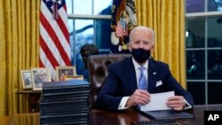 Tổng thống Joe Biden ký các sắc lệnh đầu tiên tại Phòng Bầu dục, Tòa Bạch Ốc, ngày 20/1/2021. 