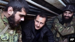 Tổng thống Syria Bashar Assad (giữa) trao đổi với quân đội Syria trong chuyến thăm của ông tới tuyến đầu khu vực phía đông Damascus của Jobar.