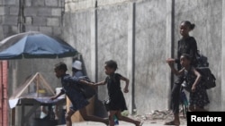 A woman and three children flee their home amid gang violence, in Port-au-Prince, Haiti, Oct. 20, 2024.