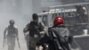 FILE - Police officers patrol after dispersing demonstrators, who were calling for help from the government and security forces after gangs attacked neighborhoods and set houses on fire, in Port-au-Prince, Haiti, Aug. 19, 2024. 