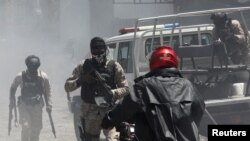 FILE - Police officers patrol after dispersing demonstrators, who were calling for help from the government and security forces after gangs attacked neighborhoods and set houses on fire, in Port-au-Prince, Haiti, Aug. 19, 2024. 