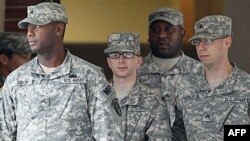 Binh nhất Bradley Manning (giữa) được đưa ra khỏi tòa án ở Fort Meade, bang Maryland