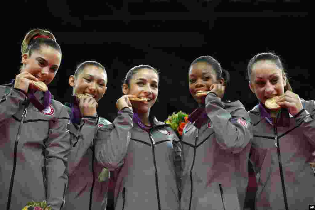 (Từ tr&aacute;i qua) Vận động vi&ecirc;n McKayla Maroney, Kyla Ross, Alexandra Raisman, Gabrielle Douglas v&agrave; Jordyn Wieber cắn v&agrave;o huy chương v&agrave;ng sau trận chung kết thể dục nghệ thuật nữ tại Olympic London 2012, 31 th&aacute;ng 7, 20