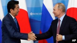 Thủ tướng Nhật Bản Shinzo Abe (trái) bắt tay Tổng thống Nga Vladimir Putin trong một buổi gặp tại Vladivostok, Nga, hôm 10/10.