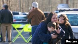 Một cậu bé đang được dỗ dành bên ngoài trường tiểu học Sandy Hook, 14/12/2012.