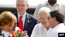 Phu nhân Rosalynn, trái, và cựu Tổng thống Mỹ Jimmy Carter nhận được một bó hoa khi đến sân bay Marti Jose ở Havana, 28/3/2011