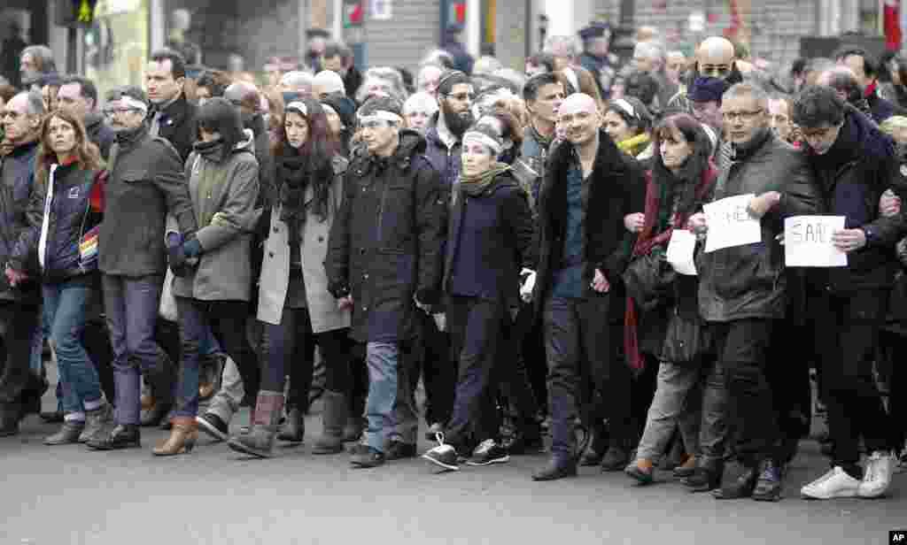 Nhân viên báo Charlie Hebdo, với họa sĩ vẽ tranh biếm họa Renald Luzier, xuống đường tuần hành cùng thân nhân của các nạn nhân thiệt mạng trong vụ tấn công siêu thị Kosher ở Paris, ngày 11/1/2015.