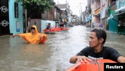 Dân chúng lội trên con đường ngập nước trong vùng thủ đô Manila trong cơn bão Fung-Wong, 19/9/14