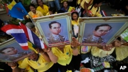 Người ủng hộ cầm chân dung của Quốc vương Thái Lan Bhumibol Adulyadej tại Bangkok. 