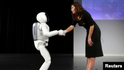 Phiên bản mới nhất của robot Asimo bắt tay sau một buổi ra mắt ở Zaventem, gần Brussels, tháng 7, 2014.