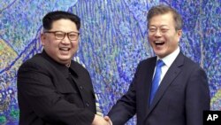 Lãnh đạo Triều Tiên Kim Jong Un (trái) và Tổng thống Hàn Quốc Moon Jae-in bắt tay tại làng Bàn Môn Điếm ở khu phi quân sự hôm 27/4/2018.