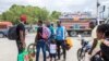 Haitian migrants who have just arrived after U.S. authorities flew them out of a Texas border city on Sunday hire moto taxis after leaving the airport, in Port-au-Prince, Sept. 19, 2021.