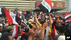 Những người ủng hộ giáo sĩ Shiite Muqtada al-Sadr cầm cờ Iraq bên ngoài nghị viện ở Khu vực Xanh của Baghdad, ngày 30 tháng 4 năm 2016.