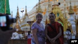 Khách du lịch chụp hình với một tu sĩ Phật giáo tại chùa Shwedagon ở Yangon.