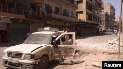 Cư dân rời bỏ nhà cửa sau khi bị pháo kích ở Houla, gần thành phố Homs, Syria, ngày 18/6/2012