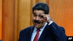 Tổng thống Venezuela Nicolas Maduro ra dấu hiệu kêu gọi lãnh đạo quân sự mở to mắt hôm 25/1.