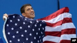 Vận động viên bơi của Mỹ Michael Phelps cầm quốc kỳ trong lễ trao huy chương cho nội dung thi đấu tiếp sức 4x100 mét hỗn hợp nam ở Olympic Rio, ngày 14 tháng 8 năm 2016.