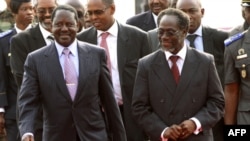 Thủ tướng Kenya Raila Odinga (trái) được Thủ tướng trong nội các của nhà lãnh đạo đương nhiệm của Côte D'Ivoire, ông Laurent Gbagbo, đón tiếp sau khi đến sân bay quốc tế Felix Houphouet Boigny ở Abidjan, ngày 3/1/2011