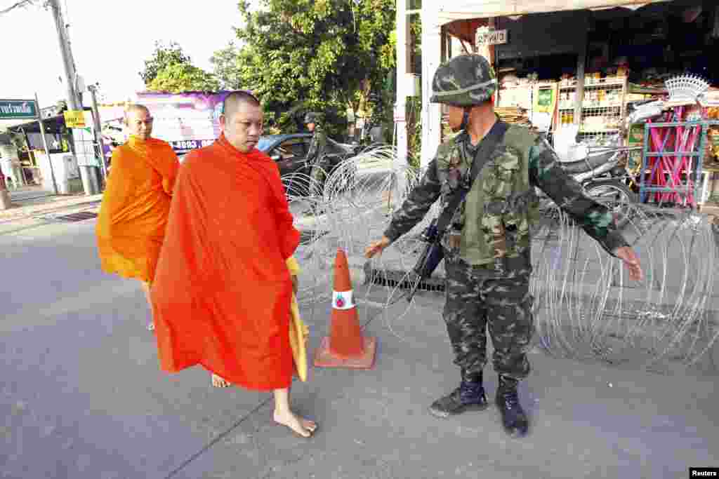 Tu sĩ Phật giáo&nbsp;đi ngang qua một chốt kiểm soát gần doanh trại của phe &#39;áo đỏ&#39; ủng hộ chính phủ trong tỉnh Nakhon Pathom ở ngoại ô Bangkok, Thái Lan, ngày 22/5/2014.