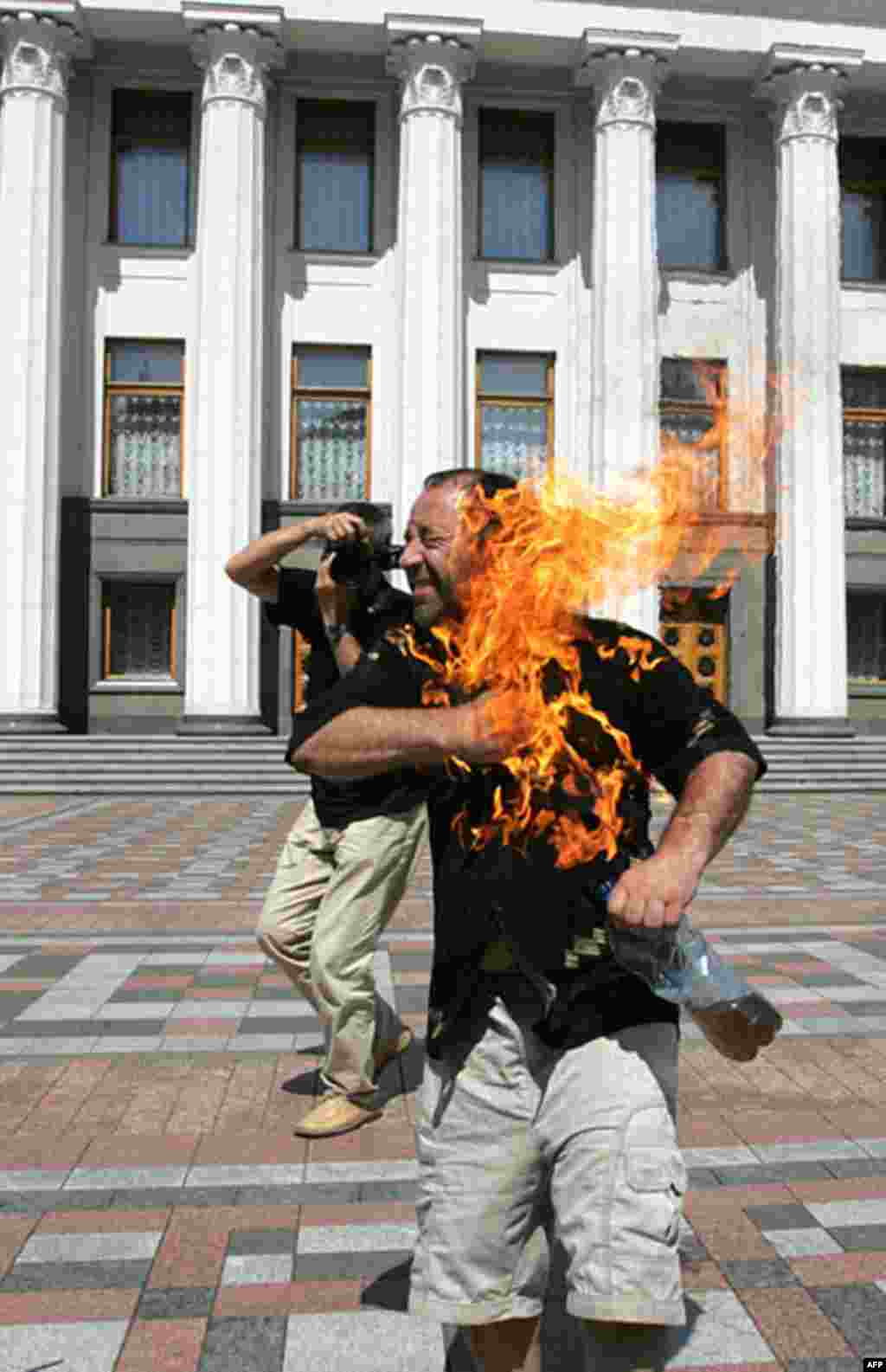 Doanh nhân 50 tuổi, Maksim Lyashenko, người Ukraina tự thiêu trước trụ sở Quốc hội ở Kiev. Ông đã biểu tình trước Quốc hội cả tuần lễ trước đó để đòi cách chức Tỉnh trưởng trong tỉnh ông vì ông này đã “ăn cướp” siêu thị của ông. 8 tháng 7, 2005. (AFP)