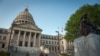 (FILES) People stand next to the Confederate Mothers statue (R) outside the Mississippi State Capitol building during the state legislature's historic vote to change the Mississippi flag in Jackson, Mississippi on June 28, 2020.