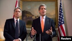 Ngoại trưởng Anh Phillip Hammond và Ngoại trưởng Hoa Kỳ John Kerry (phải) phát biểu tuyên bố tại một cuộc họp báo ở London, 21/2/2015. 