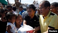 Tổng thống Philippines Benigno Aquino phân phối hàng cứu trợ cho nạn nhân bão Haiyan ở thị trấn Palo, tỉnh Leyte, miền trung Philippines.