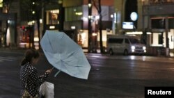 Gió mạnh và mưa lớn vì bão Jelawat trong khu mua sắm Ginza ở Tokyo