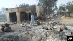 Một người đàn ông đi qua căn nhà bị thiêu rụi sau một vụ tấn công của Boko Haram ở thị trấn Dalori, 5 km từ Maiduguri, Nigeria, ngày 31/1/2016.