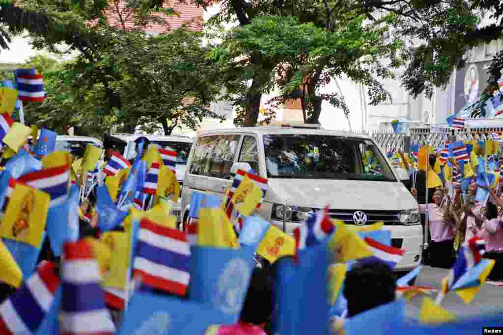 Dân chúng vẫy cờ trong khi đoàn xe của Quốc vương Bhumibol Adulyadej rời bệnh viện Siriraj ở Bangkok, 1/8/13